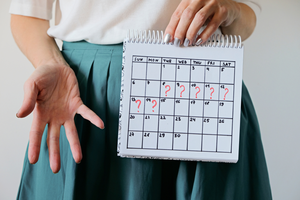 Can A Car Accident Cause Your Period To Start? 1 woman holds calendar reflecting menstruation cycle
